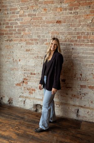 Professional fashion portrait series against rustic brick wall showing casual business style and relaxed poses.