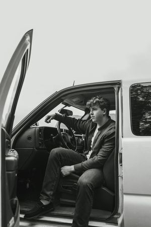 A sequence of three black and white photos showing someone entering and sitting in a car door.