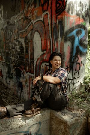 A sequence of candid moments captured against a graffiti wall in an outdoor urban setting.