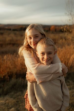 Two figures share tender moments in a golden field at sunset, captured in a series of warm-toned photographs.