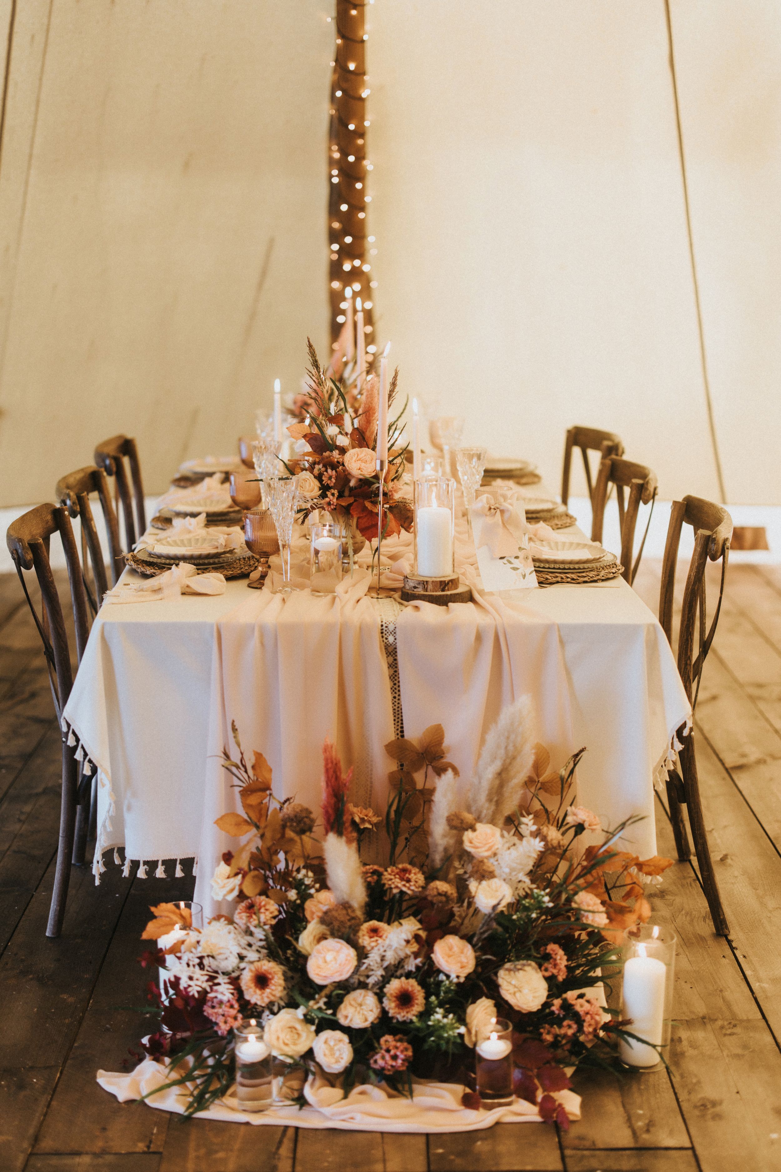 Elegant wedding reception tables with white linens, dark chairs, and romantic floral arrangements at Nuddock Wood Lake.