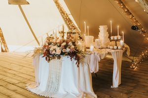 Elegant wedding reception table with white tablecloth, floral arrangements and candles at Nuddock Wood Lake.