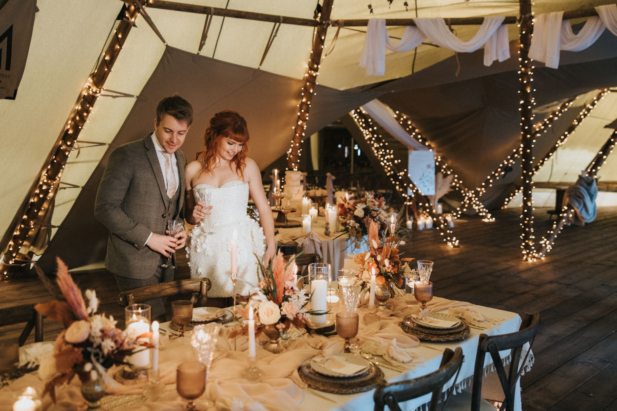Wedding reception table decorated with rustic elements and string lights creating a warm atmosphere at Nuddock Wood Lake.