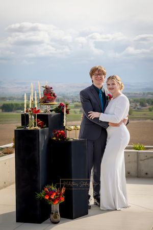 Garman Hill poolside jewel tone wedding couple posing with black pillars flowers, candles and cake