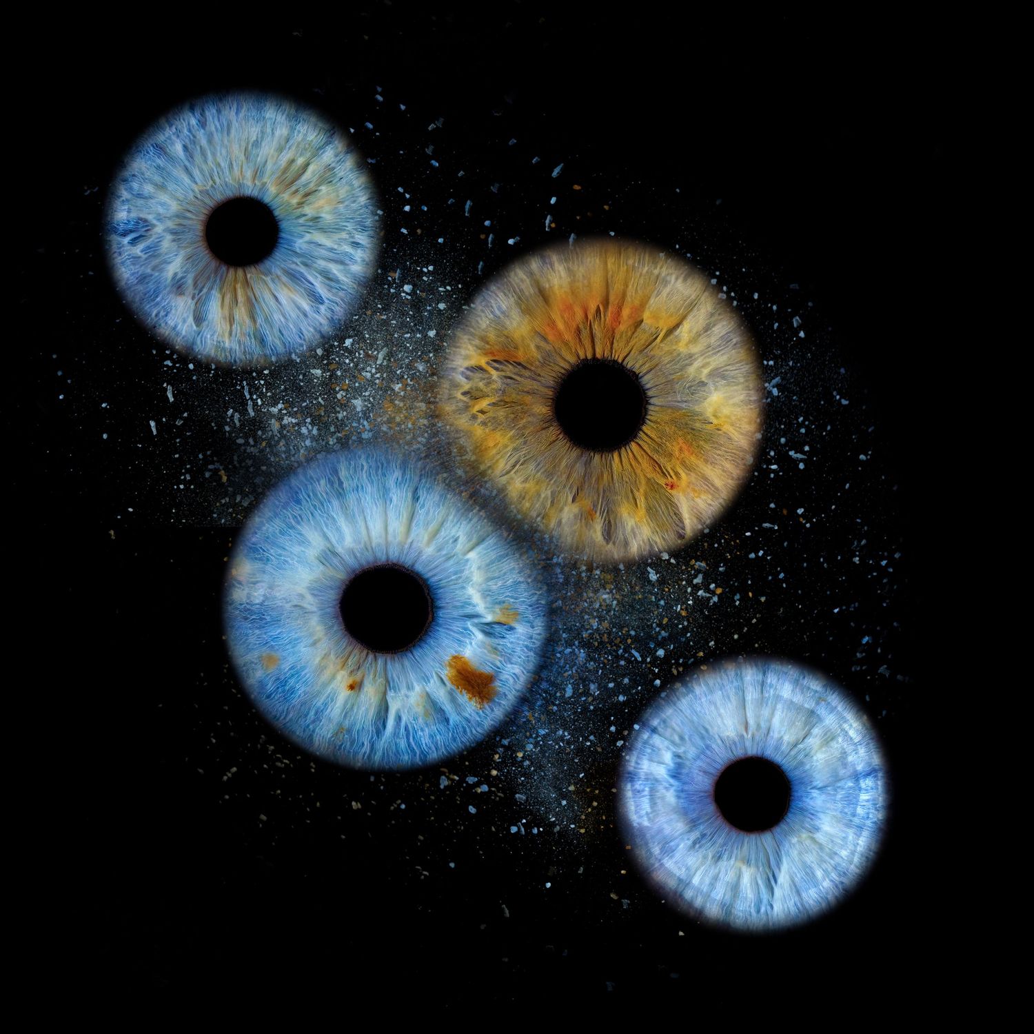 Close-up view of four vibrant human irises in blue and amber colors against a dark background with scattered light spots.