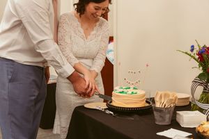 Newlywed couple cuts into their simple wedding cake together at the reception.
