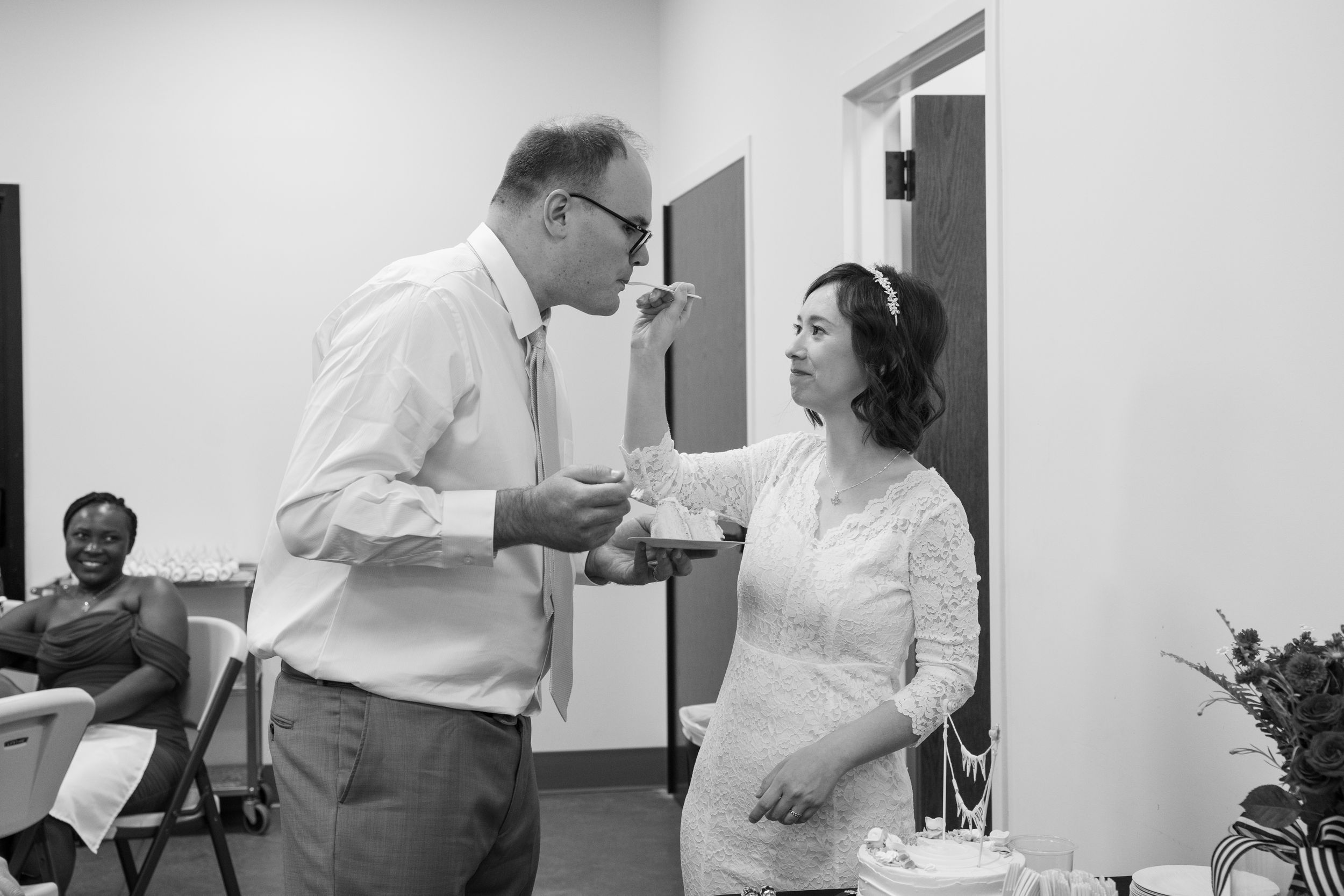 Black and white photo of couple having an animated conversation at their wedding reception.