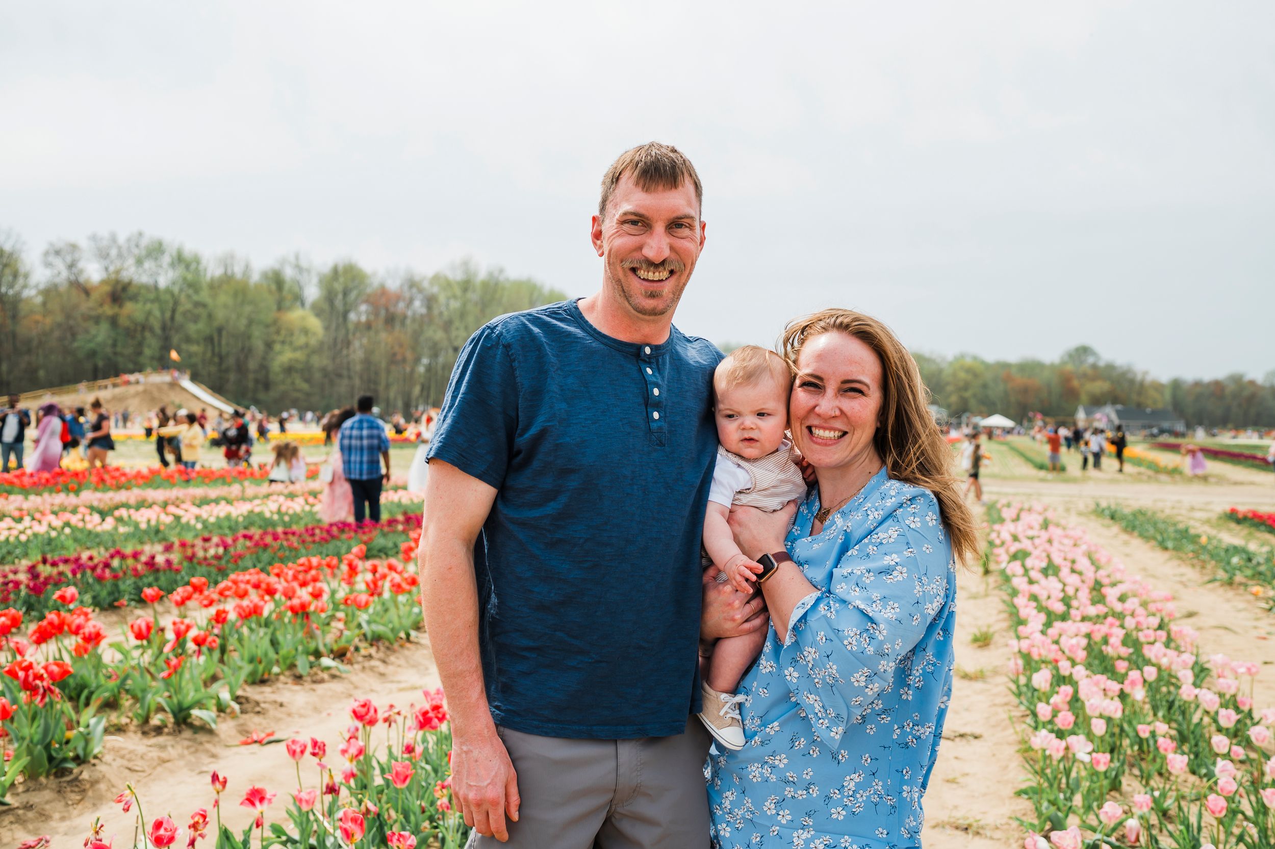 People enjoy a spring day together among colorful blooming tulip fields on a sunny afternoon.