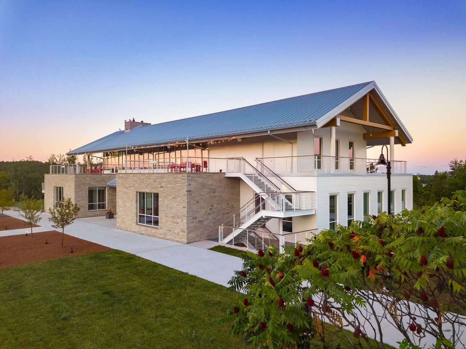 Egg Harbor Library, a Modern two-story building with stone base and white upper level features wrap-around deck at sunset.