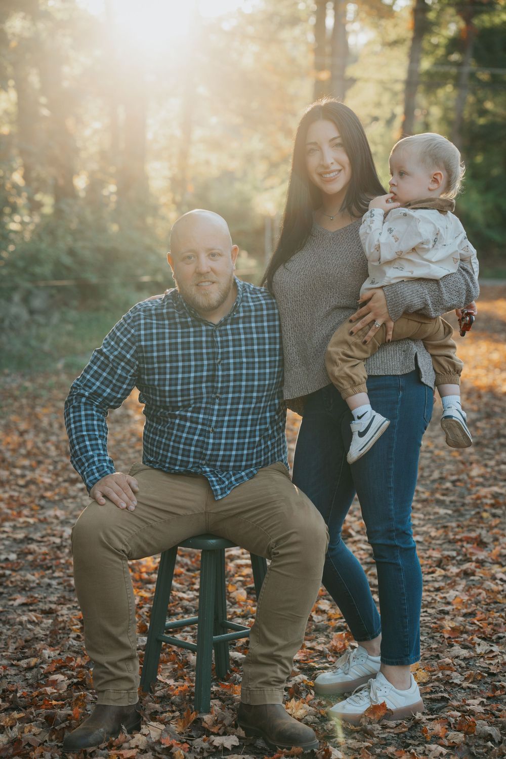 Family sharing playful moments together on fallen autumn leaves during sunset. Family Photoshoot. Family Photographer