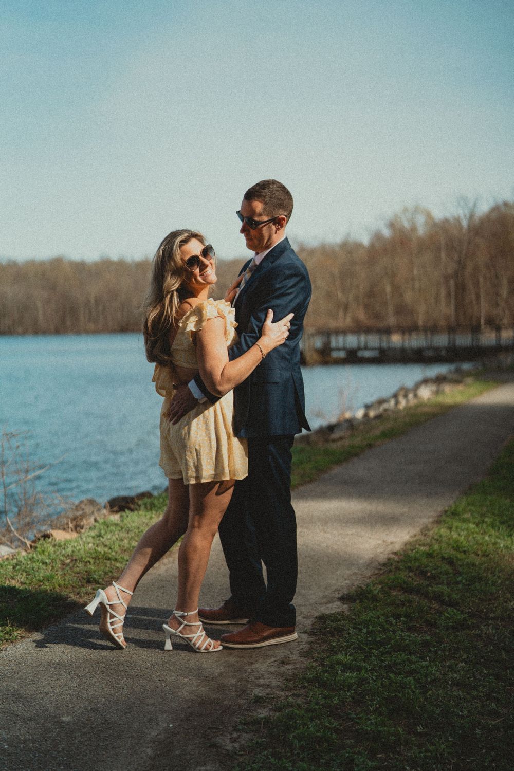 Romantic couple dancing together on a lakeside path during golden hour. Engagement photoshoot engagement photography