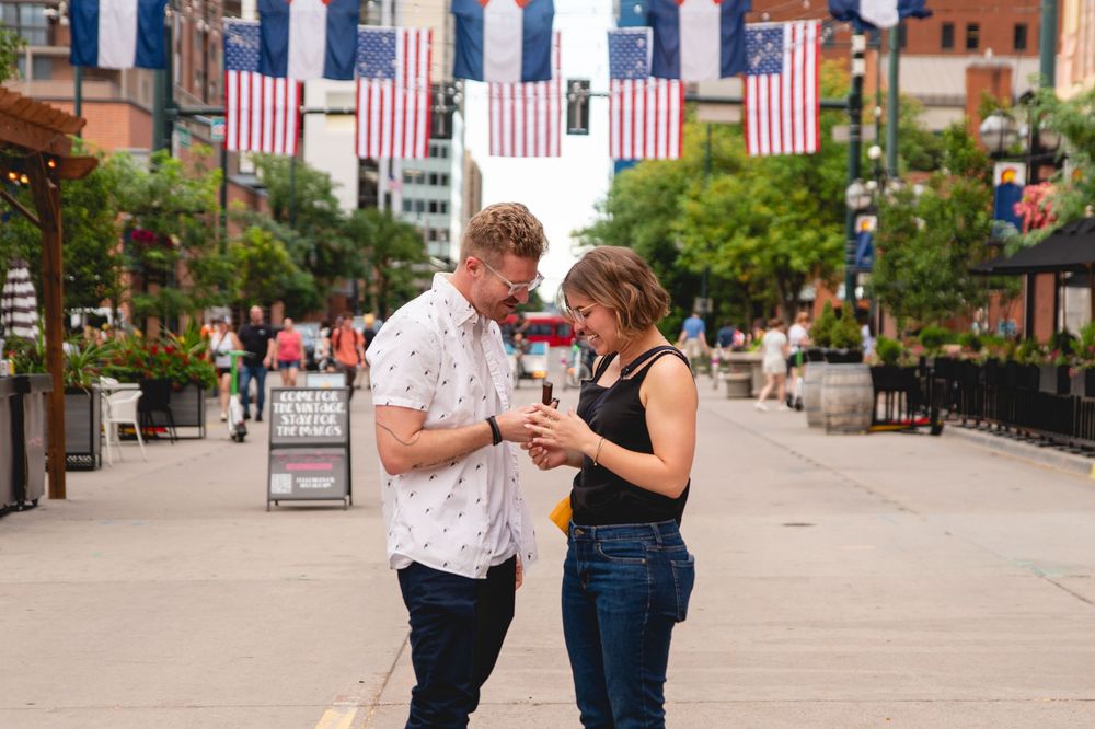 American flags line a city street as a couple dances together on a summer afternoon.