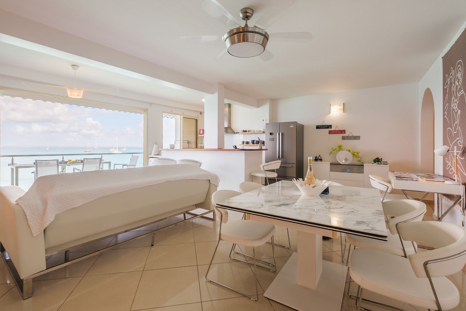 Modern white apartment interior design with sleek furniture and curved architectural details bathed in natural light.