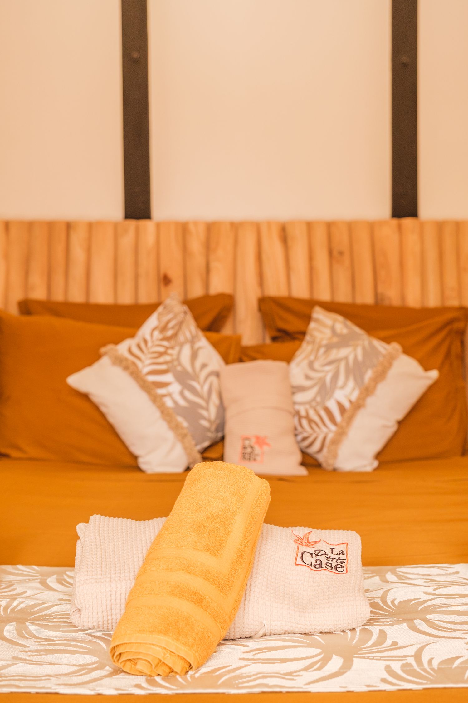 Orange and white bedding with decorative throw pillows arranged on a bed featuring zebra print accents.