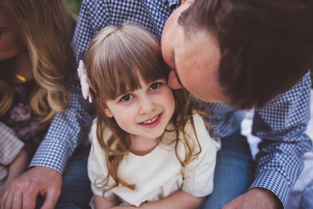 Five joyful outdoor family portraits showing playful interactions and affection in a garden setting.
