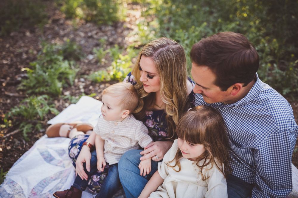 Family enjoying a tender moment together outdoors during a golden hour photoshoot in nature.
