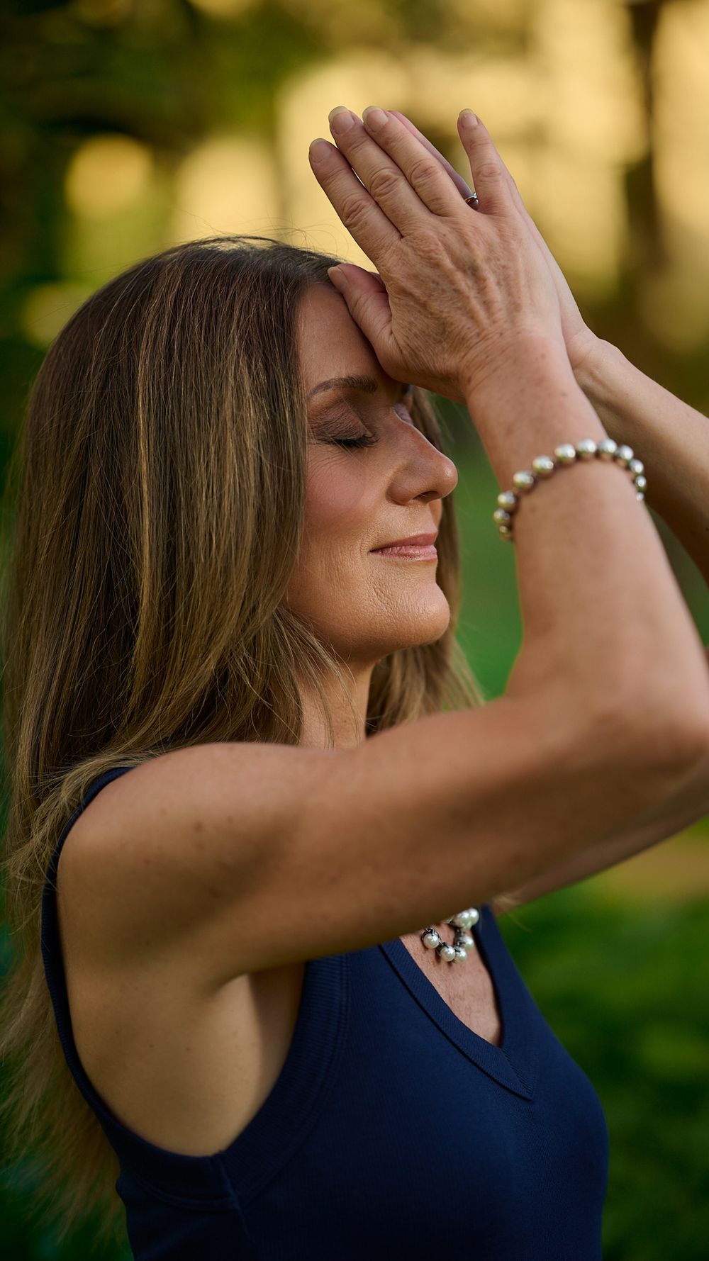 A series of artistic profile photographs showing someone in a navy blue top with eyes closed against a nature backdrop.