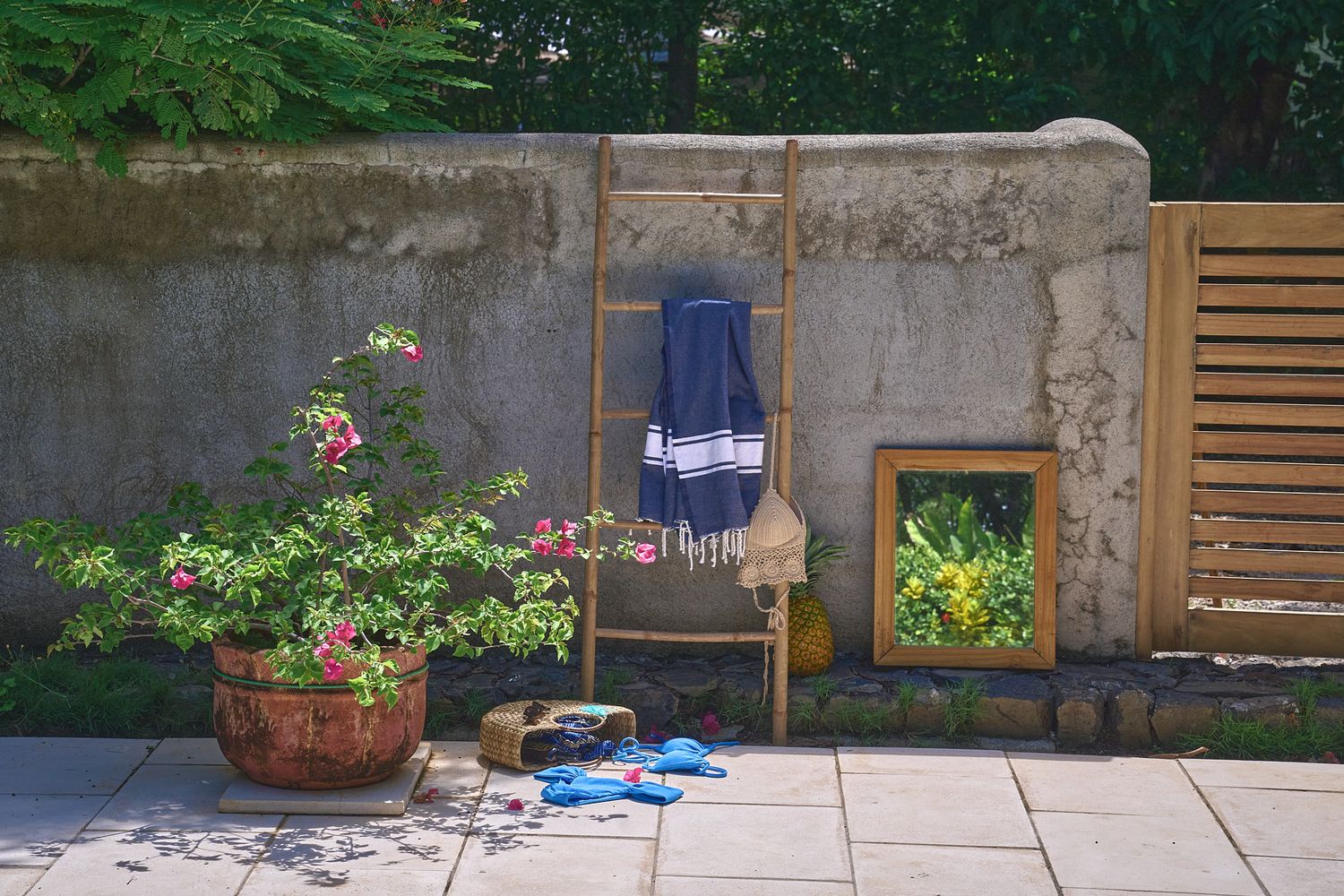 A row of planted garden boxes with brick walls and wooden fencing creates an inviting backyard patio space.