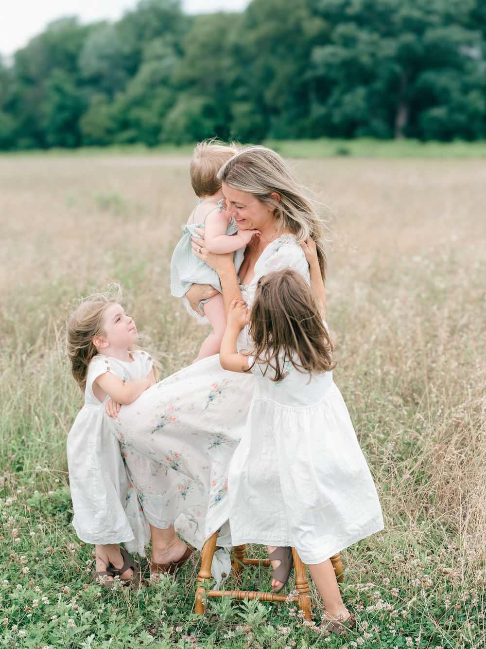 Dr. Jill of Womb Wellness PT is smiling and holding her youngest daughter during family photos in Monmouth County.