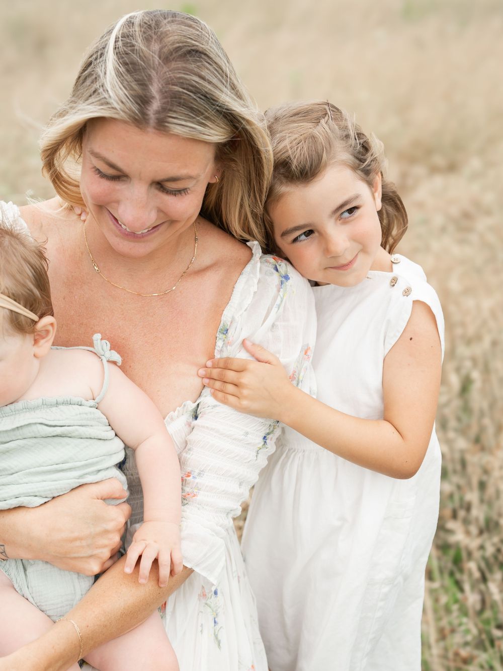 A daughter wraps her arms around her mother's arm.