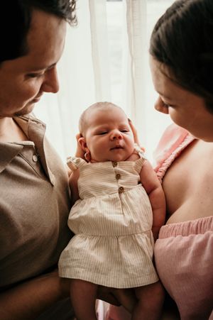 Tender family moment captured in warm tones with soft window light.