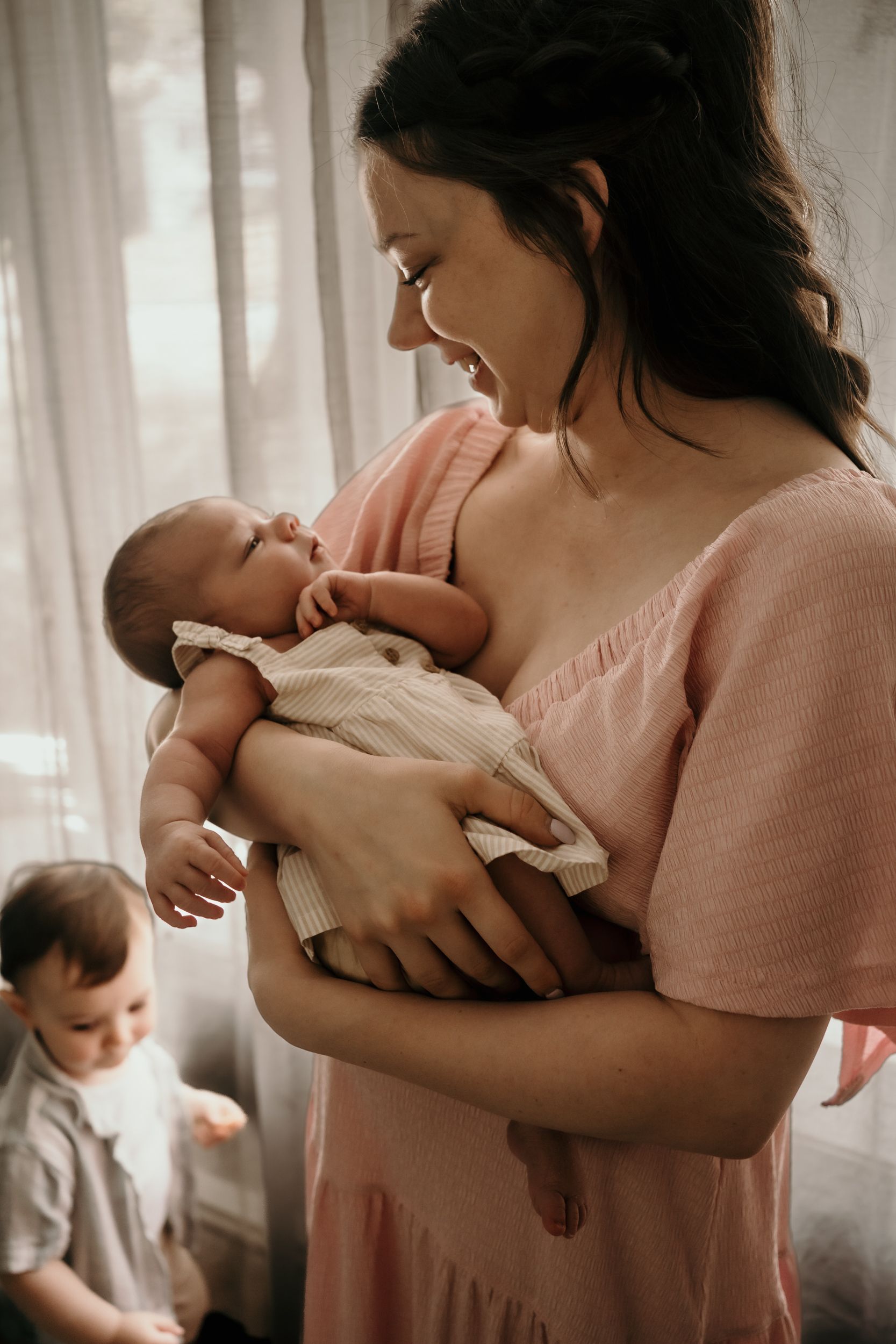 Intimate nurturing moment photographed in gentle natural window light.