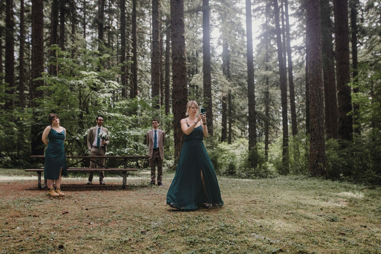 A magical forest wedding ceremony takes place in a misty clearing surrounded by tall evergreen trees.