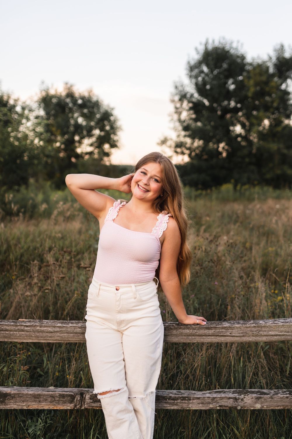 Senior girl posing on a fence at Roselle Park in Ada, MI.