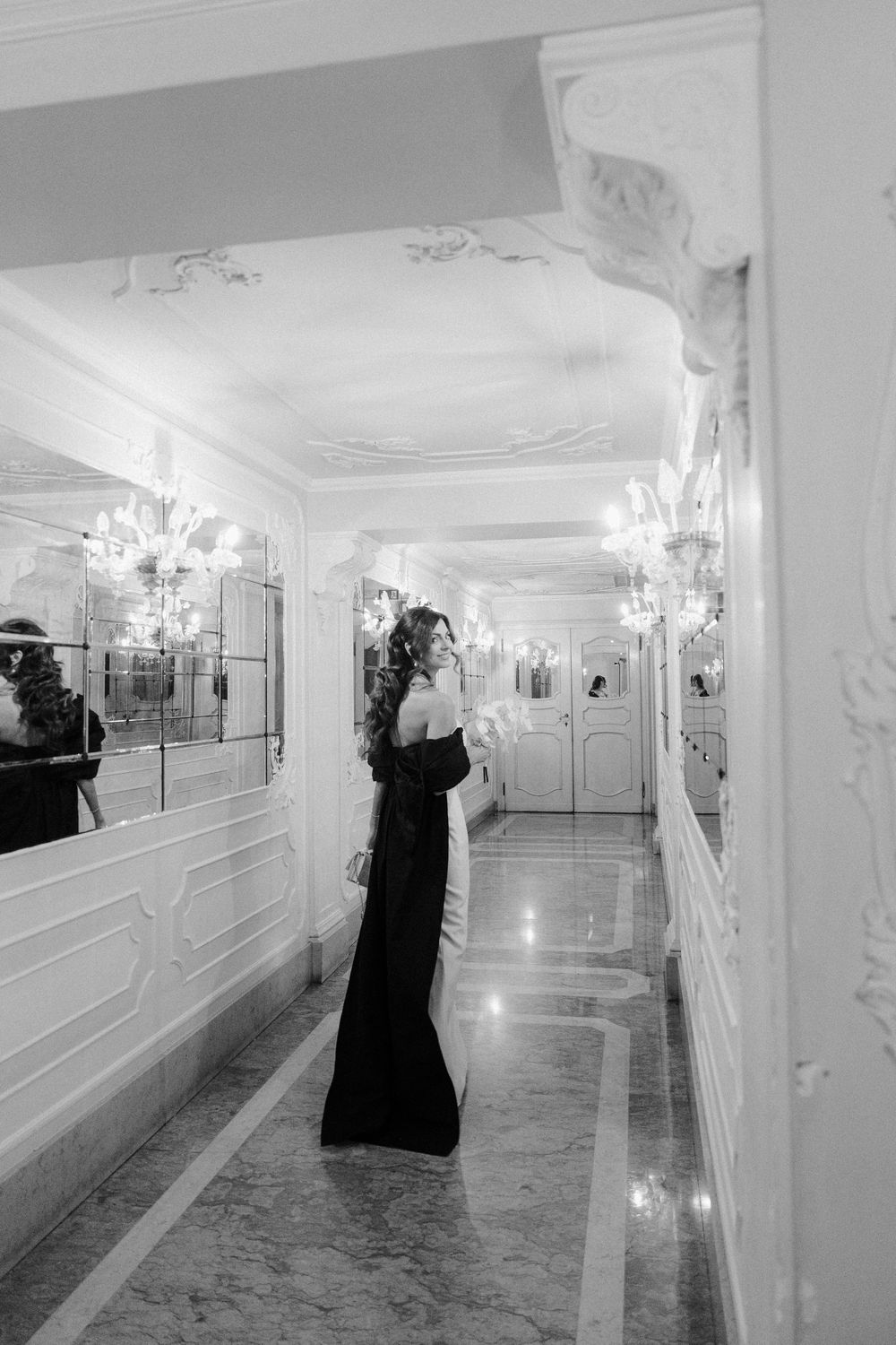 Elegant hallway with crystal chandeliers and mirrored walls in classic hotel interior. Photoshoot by Venice Photographer Alina Indi