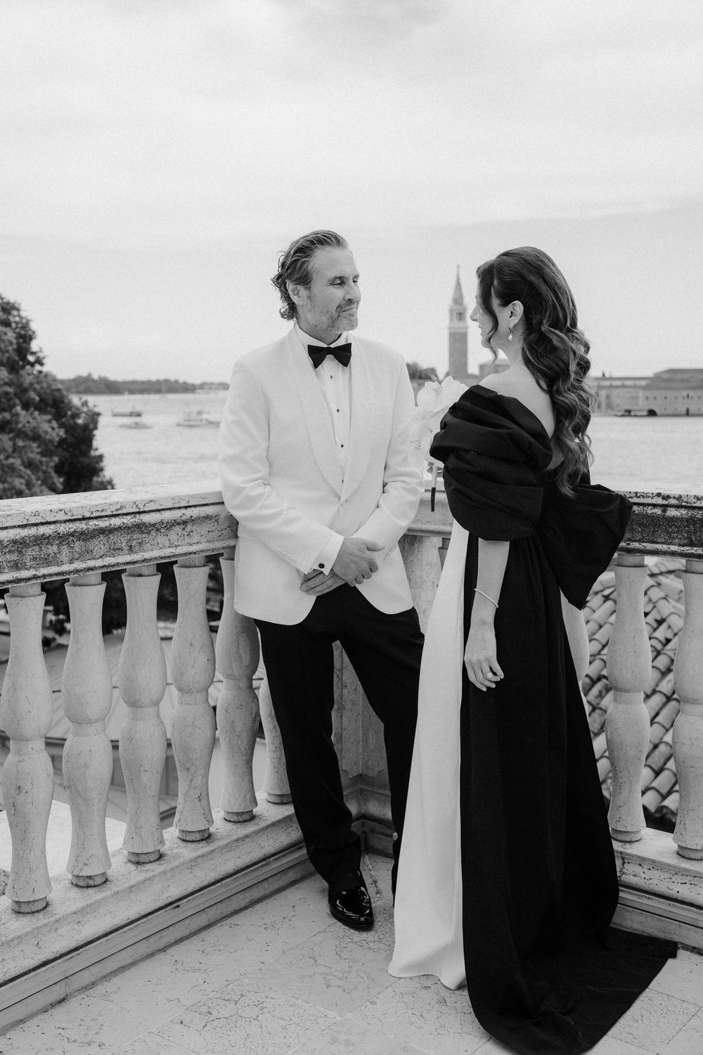 Black and white photo of couple sharing tender moments on a classic stone terrace. Photoshoot by Venice Photographer Alina Indi
