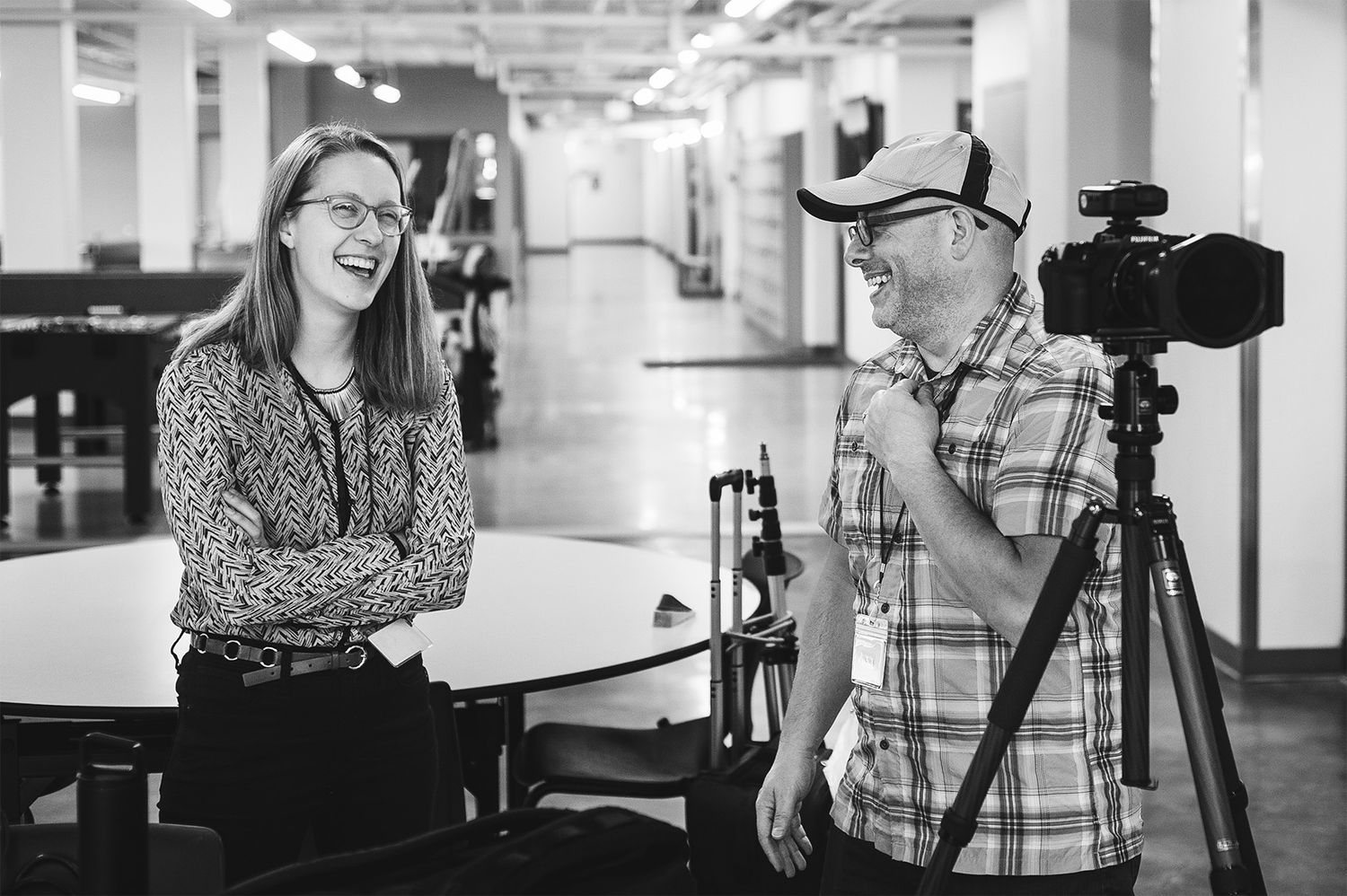John Magnoski with a camera on a tripod laughs with his client while photographing inside the Salvation Army headquarters in Minneapolis, MN