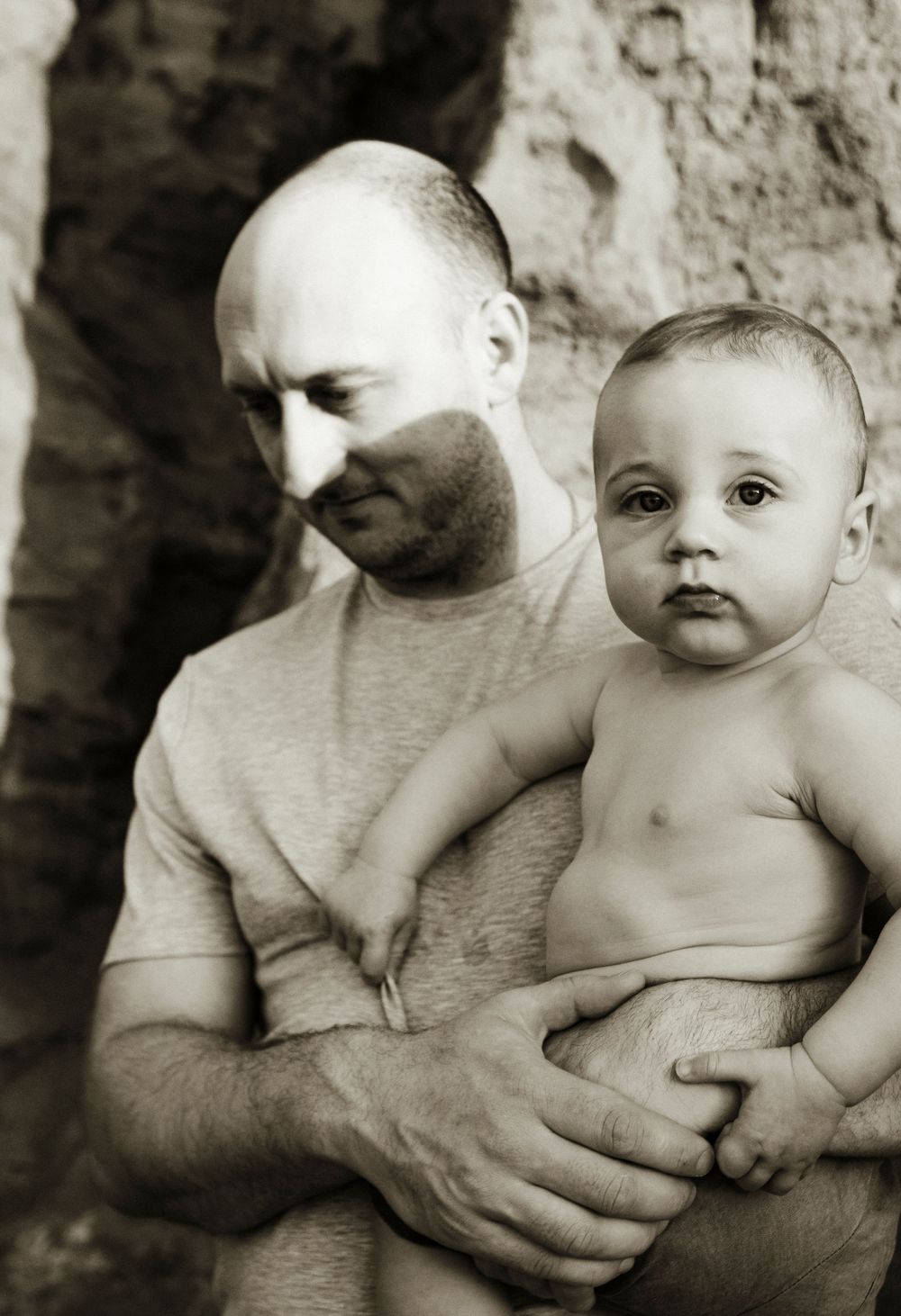 Black and white artistic portrait of tender parental moment with infant.