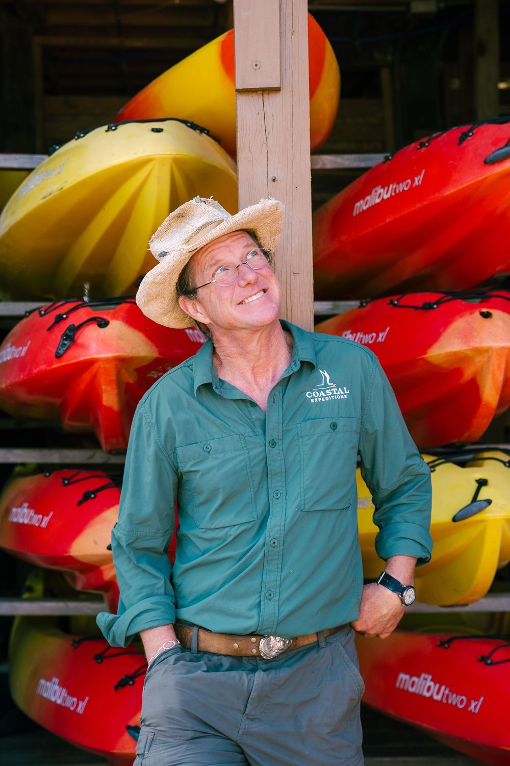 A display of colorful kayaks on racks with red and yellow boats visible.