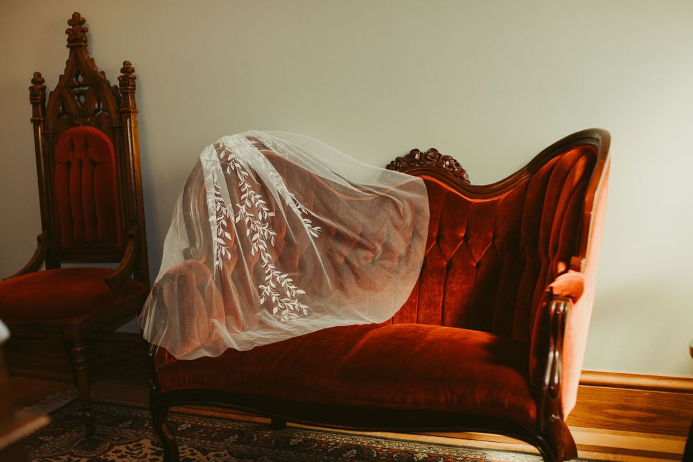 Vintage furniture and antique chaise lounge in warm-lit room setting.