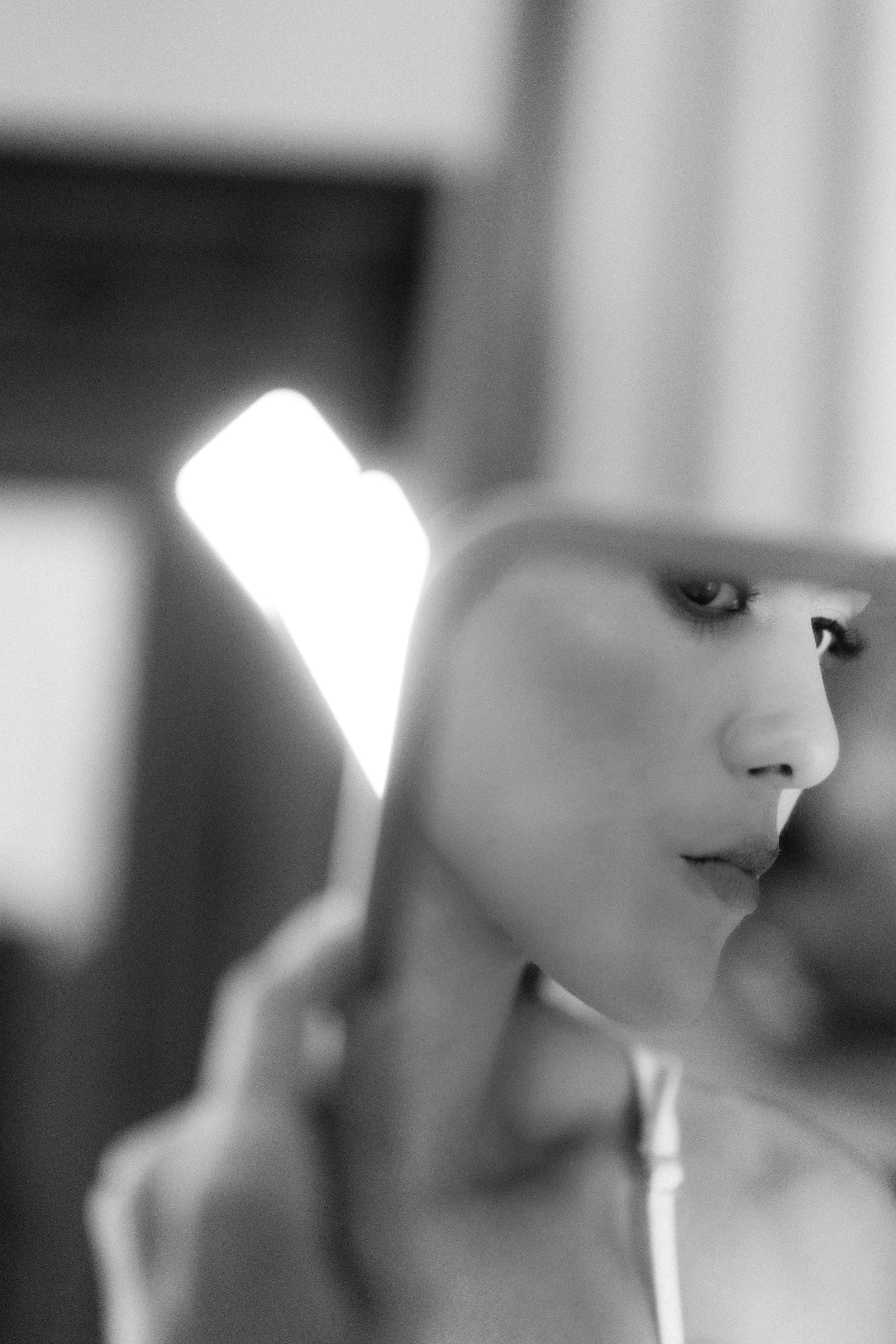 Artistic black and white portrait photograph with dramatic side lighting.