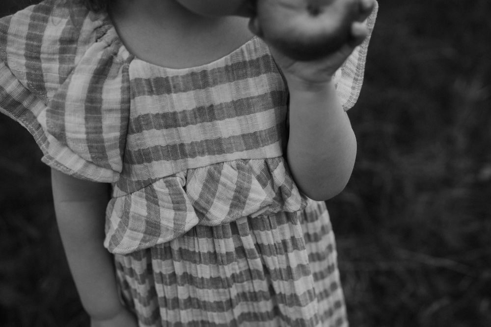 Close-up detail of gingham dress with ruffled sleeve in black and white.