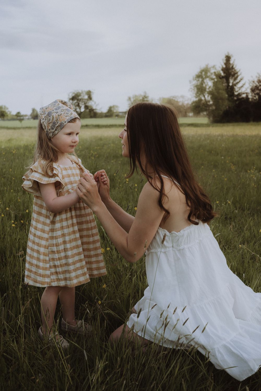Sweet interaction between parent and child in flowering meadow.