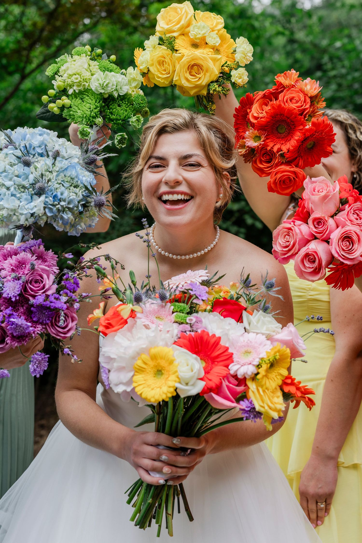 A series of colorful wedding bouquets featuring yellow, red, pink, blue and purple flowers arranged in a rainbow sequence.