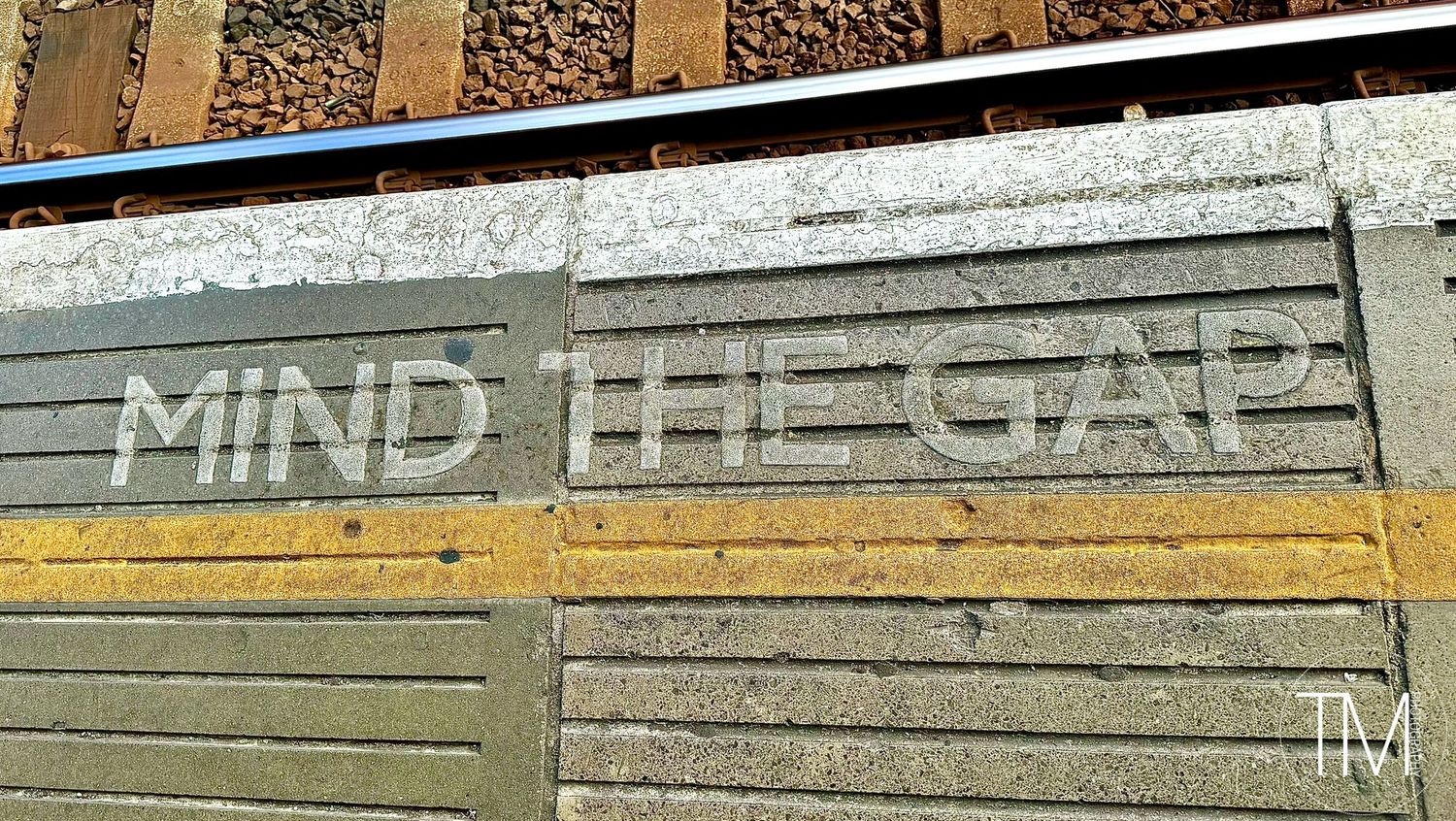 Mind the Gap warning painted in white letters on platform edge.