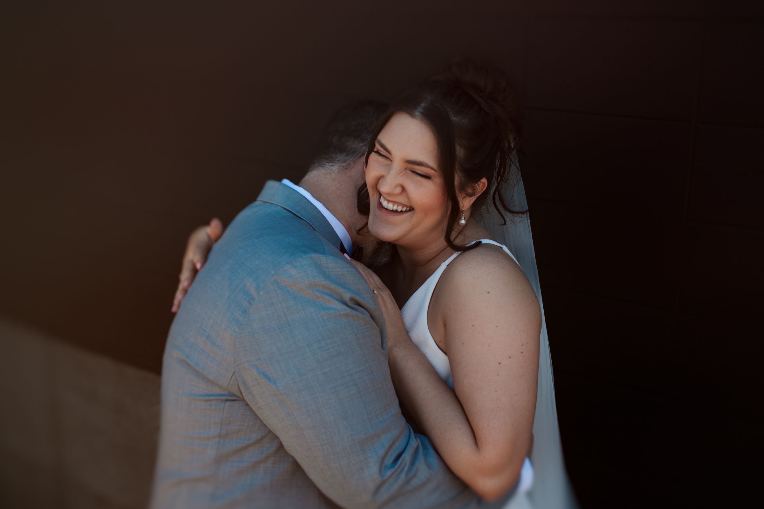 A romantic couple embraces during an intimate dance at a dimly lit event in Indianapolis Indiana.