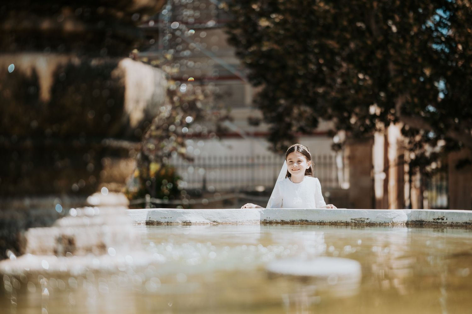 Outdoor baptism ceremony setting with natural sunlight filtering through trees.