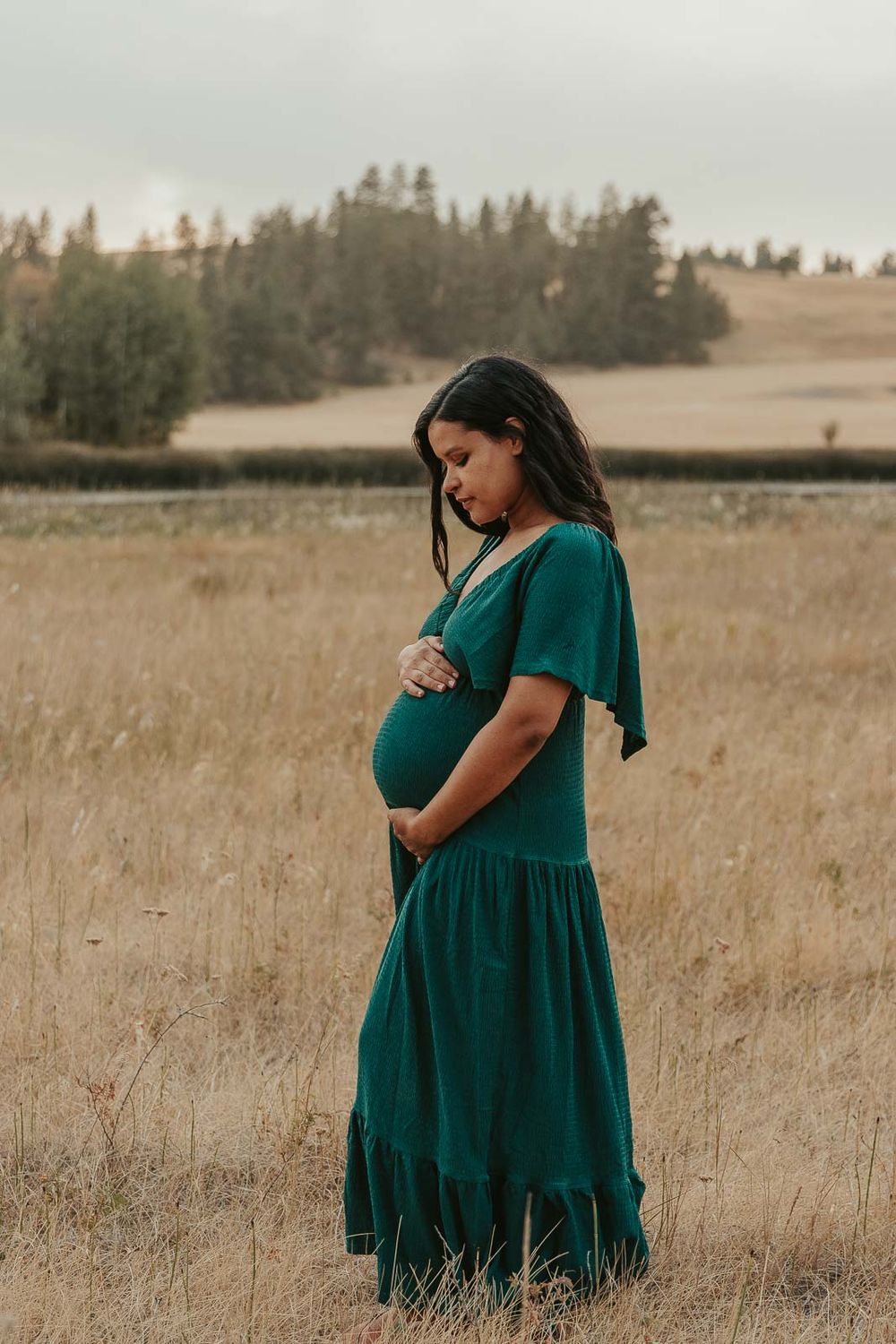 Golden hour maternity photo with Spokane maternity photographer Elishia Jackson, featuring a peaceful outdoor backdrop, side view of mother