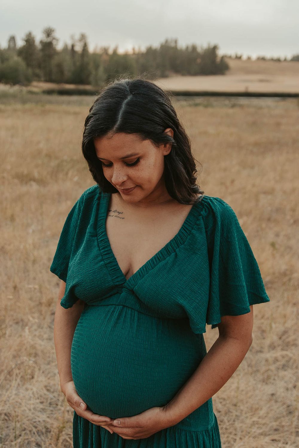 Golden hour maternity photo with Spokane maternity photographer Elishia Jackson, featuring a peaceful outdoor backdrop, close up