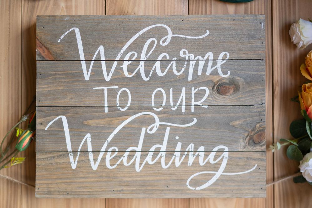 Rustic wooden wedding welcome signs with white calligraphy text.