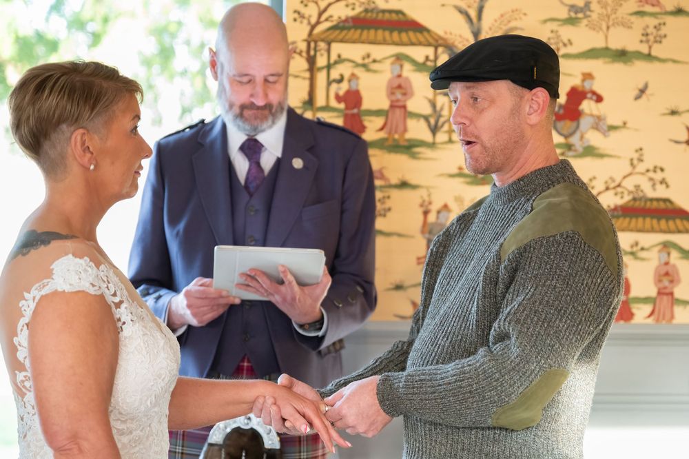 A romantic first dance moment at a Scottish wedding featuring traditional kilts and a white lace wedding dress.