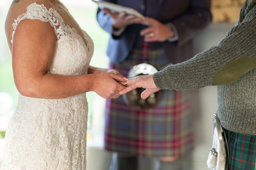 Couple embracing during their wedding dance, with the groom in traditional Scottish attire.