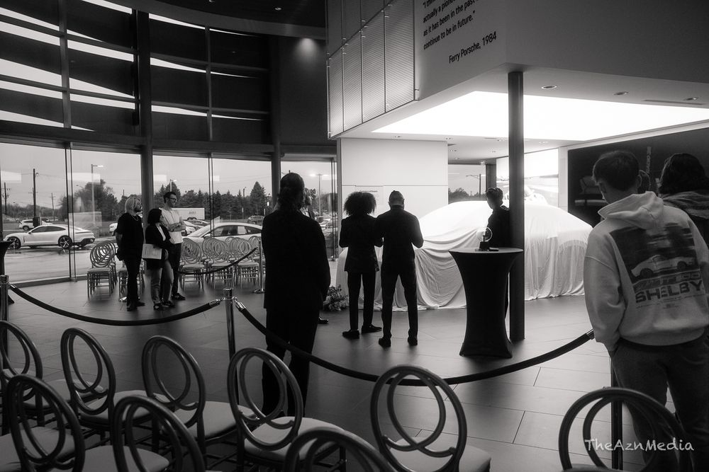 Silhouettes of people gathering in a modern event space with large windows.