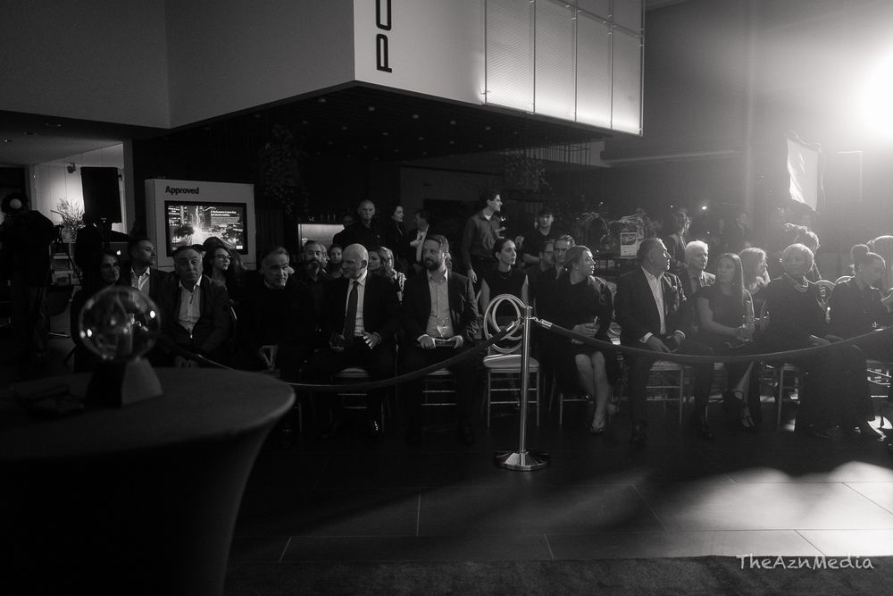 Black and white photo of a crowded audience seated in rows at an indoor event.