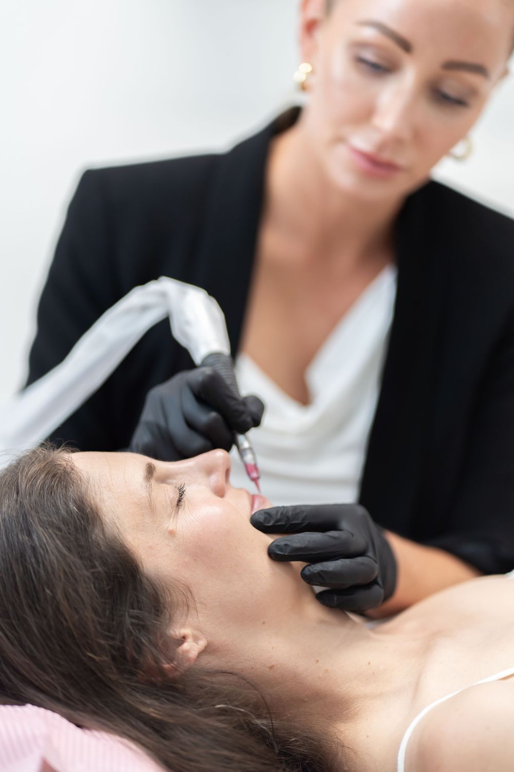 Beauty specialist performing facial treatment using professional tools.