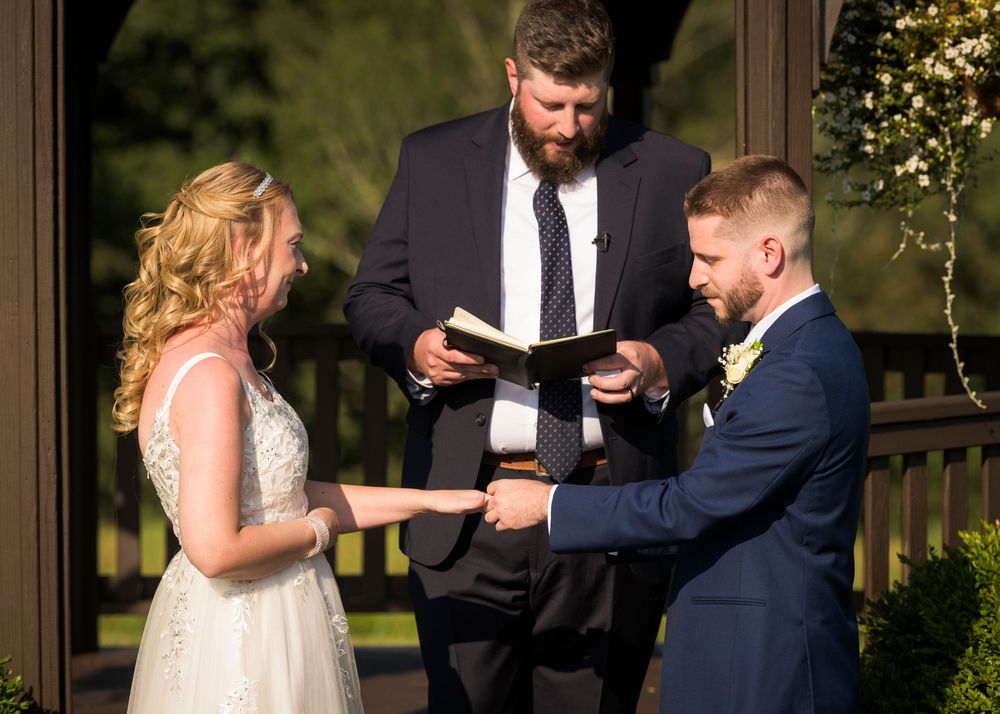 Couple sharing a playful moment during first dance at outdoor wedding reception.